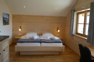 a bedroom with a bed in a room with wooden walls at Beim Winkel Max in Trauchgau
