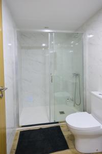 a white bathroom with a shower and a toilet at CASA ORIGENS ll in Seia