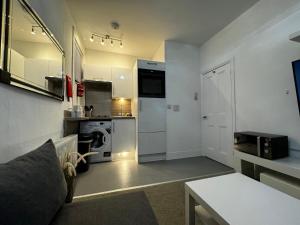 eine kleine Küche mit Waschmaschine und Trockner in einem Zimmer in der Unterkunft Galaxy apartments Brentwood in Brentwood