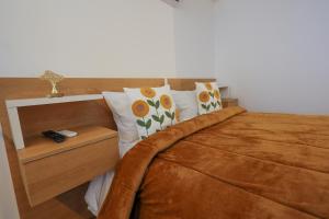 a bedroom with a brown bed with two pillows at CASA ORIGENS ll in Seia