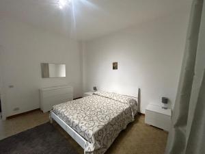 una camera bianca con un letto e due comodini di Solymar House Lacco Ameno a Ischia