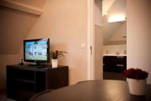 a living room with a television on a table at B&B Innbrugas in Bruges