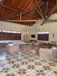 un grand salon avec des canapés et un lustre dans l'établissement Finca Napoles, à Santa Fe de Antioquia