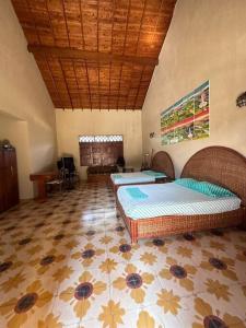 - une chambre avec deux lits et un plafond en bois dans l'établissement Finca Napoles, à Santa Fe de Antioquia