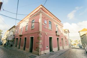 un bâtiment rose sur le côté d'une rue dans l'établissement Best Houses Portugal Residence, à Peniche