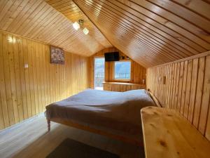 - une chambre avec un lit dans une pièce en bois dans l'établissement Акорди Плеса, à Yaremtche