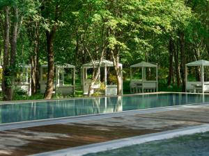 a swimming pool with trees and a gazebo at Rosevia Resort & Spa in Jastrzębia Góra +57 photos