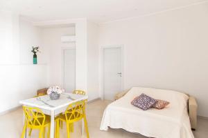 a room with a table and yellow chairs and a bed at Il Borgo in Formia