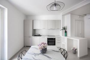 a white kitchen with a table with flowers on it at Il Borgo in Formia