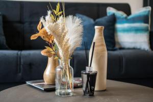 a table with a vase with feathers in it at BethnalGreen Apartments by Sleepy in London