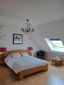 1 dormitorio con cama y lámpara de araña en B&B La Rive - Le Mont Saint Michel, en Ardevon