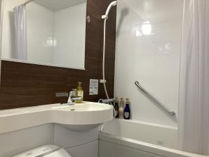a bathroom with a sink and a toilet and a tub at Hotel Alpha-One Yatsushiro in Yatsushiro