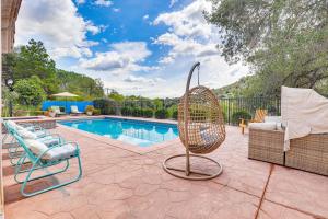 a swimming pool with a rattan chair and a swing at Escondido Home Private Pool, 2 Grills and Fire Pit! in Escondido