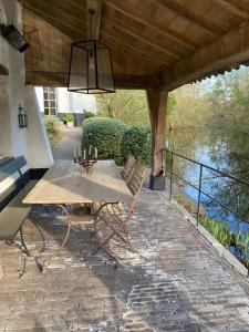 een picknicktafel op een patio met uitzicht op een rivier bij Etablo B&B in Bornem