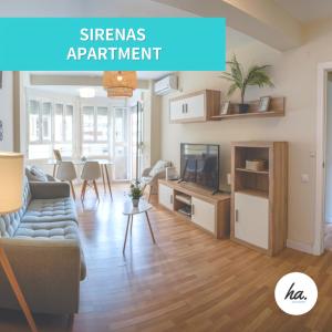 a living room with a couch and a tv at Sirenas Playa Ha Apartment in Cádiz