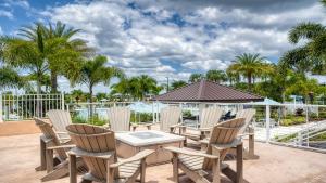 un patio con mesa, sillas y piscina en Solara Resort 6br Fancy Movie World Pool Spa Villa By Disney 8913, en Kissimmee