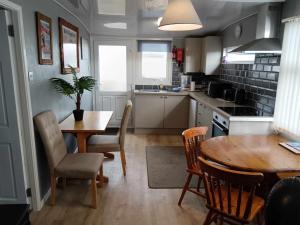 a kitchen and dining room with a table and chairs at yeolde woodern seashak 2 bed new kitchen Bathroom FREE electric dog friendly LOW PRICES ENJOY YOUR STAY in Bridlington