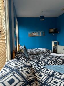 a bedroom with two beds and a blue wall at Winter Gardens Flat 3 - Family Apartment in Blackpool