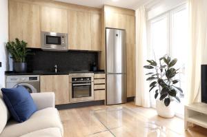 eine Küche mit einem Kühlschrank aus Edelstahl in der Unterkunft Madrid Río Suites in Madrid