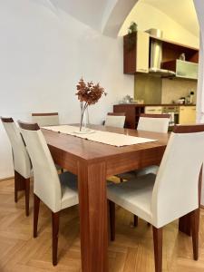 a dining room table with white chairs around it at Apartment Sophie - Old Town in Bratislava