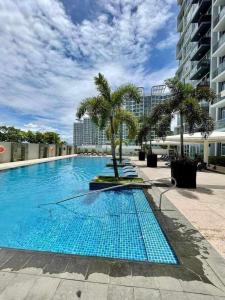 a large swimming pool with palm trees and a building at Mactan Cebu Beach Condo in Punta Engaño +23 photos