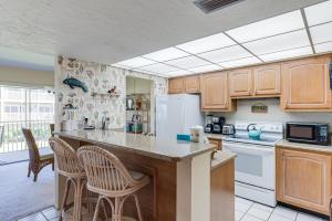 a kitchen with wooden cabinets and a white refrigerator at Sanibel Siesta on the Beach unit 501 condo in Sanibel