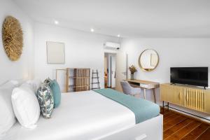 Biała sypialnia z dużym łóżkiem i biurkiem w obiekcie Urban Tech Retreat: Modern Hubs for Remote Living w Lizbonie