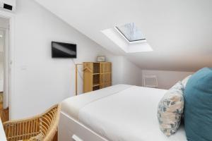 biała sypialnia z łóżkiem i świetlikiem w obiekcie Urban Tech Retreat: Modern Hubs for Remote Living w Lizbonie