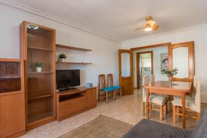 ein Wohnzimmer mit einem Esstisch und einem TV in der Unterkunft VISTAS A DOS MARES La Manga del Mar Menor KM10 ISLA GROSA 2dormitorios in La Manga del Mar Menor