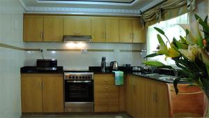 a kitchen with wooden cabinets and a stove top oven at Westland's Gardens Suites One in Nairobi