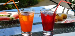two drinks on a table with a plate of fruit at Westland's Gardens Suites One in Nairobi