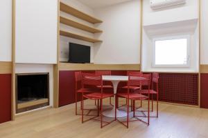uma sala de jantar com cadeiras vermelhas e uma mesa e uma televisão em Duomo View Apartment em Florença