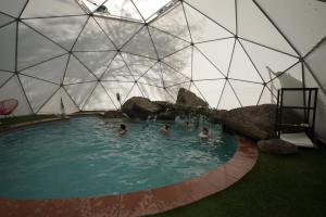 un gruppo di persone in una piscina in una cupola di Refugio Atreyu a Santiago