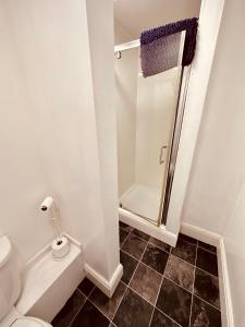 a white bathroom with a shower and a toilet at Winter Gardens Flat 3 - Family Apartment in Blackpool