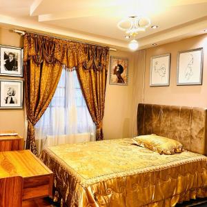 ein Schlafzimmer mit einem Goldbett und einem Fenster in der Unterkunft Maison de 4 chambres avec jardin clos et wifi a Annemasse in Annemasse