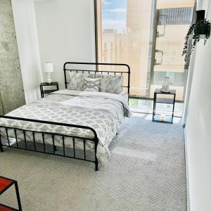 1 dormitorio con cama y ventana grande en Hollywood Luxury Stay & FREE PARKING en Los Ángeles