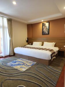 a bedroom with a large bed and a rug at Thimphu Deluxe Hotel in Thimphu