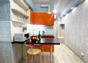 kuchnia z pomarańczowymi szafkami i czarnym blatem w obiekcie NewStyle w Charkowie