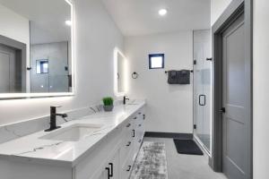 a white bathroom with two sinks and a mirror at Vizcaya #1 - Moab's Newest Luxury Rental (Hot Tub) in Moab