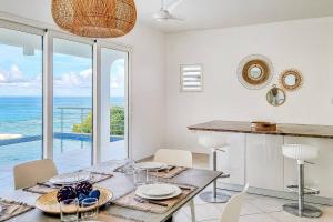 een eetkamer met een tafel en uitzicht op de oceaan bij Villa Twin Palms 3 bedrooms in Dawn Beach