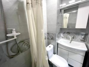 a bathroom with a white toilet and a sink at NewStyle in Kharkiv