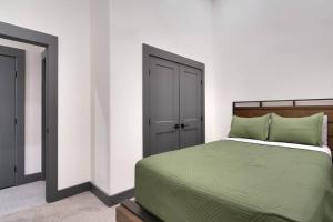 a bedroom with a green bed and a closet at Vizcaya #1 - Moab's Newest Luxury Rental (Hot Tub) in Moab