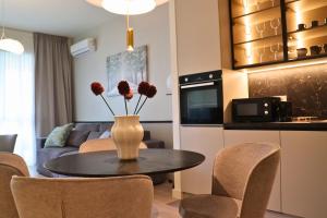 a kitchen and living room with a table and chairs at Aglaya 3 - Luxury 2BR Apartment in Belgrade +8 photos