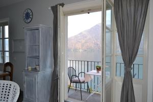 a room with a balcony with a view of the water at Solivonatural Apartment in Cannobio