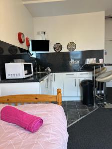 a small kitchen with a bed and a microwave at Winter Gardens Flat 2 - Studio in Blackpool