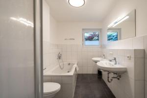 bagno con 2 lavandini, vasca e servizi igienici di Am Hörnle a Burgberg im Allgäu