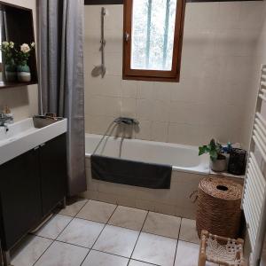 La salle de bains est pourvue d'une baignoire et d'un lavabo. dans l'établissement Villa 80 m2 jardin terrasse 3 chambres Provence, à Volx