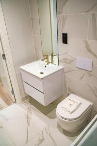 a white bathroom with a toilet and a sink at Smart Central Birmingham 1 Bed Apartment in Birmingham