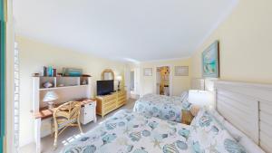 a bedroom with two beds and a desk and a television at Lakeside Retreat in Gated Litchfield by the Sea in Pawleys Island