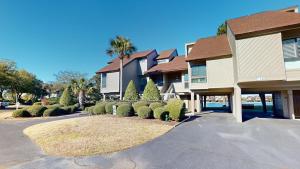 a house with a lot of bushes in a driveway at Lakeside Retreat in Gated Litchfield by the Sea in Pawleys Island